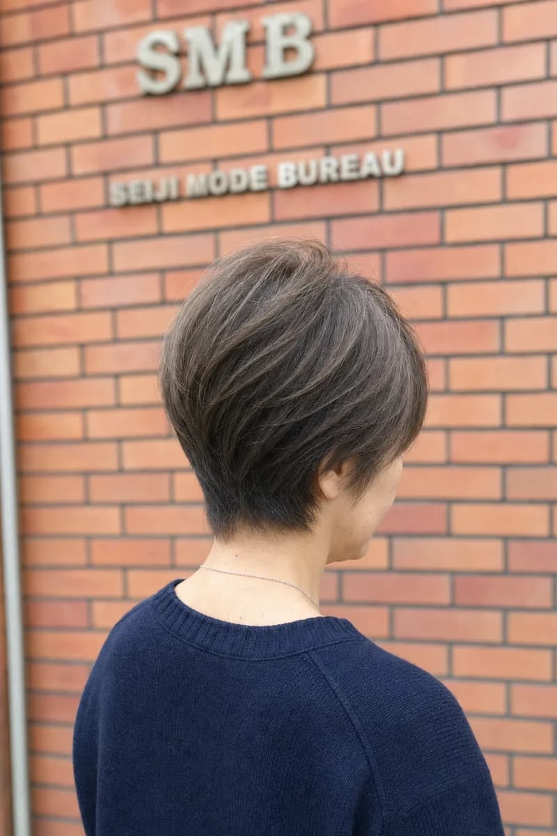 えり足を短く整えたショートレイヤーの女性を後ろから見た姿