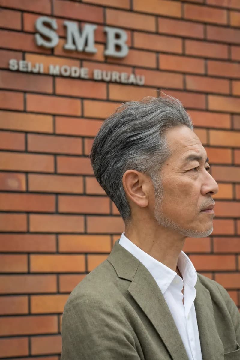 後ろに流したグレイヘアのショートスタイルの男性の横顔