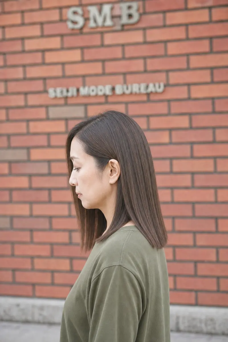 肩までの長さをまっすぐ切りそろえたストレートヘアの女性の横顔