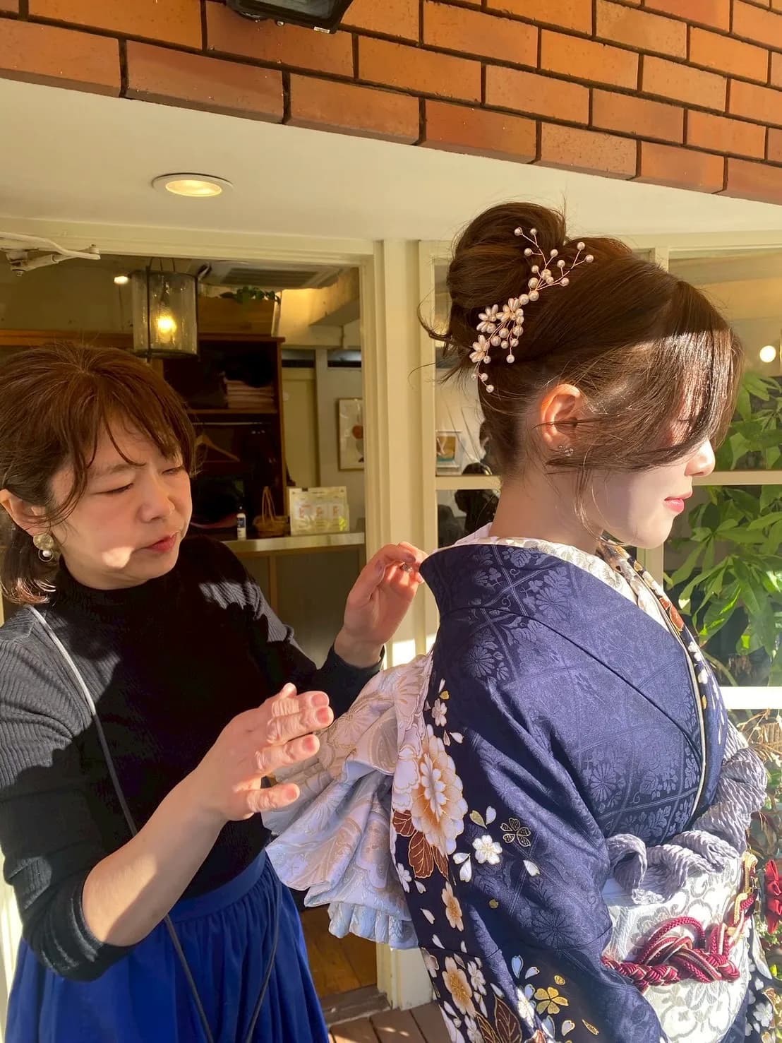 お客様の着付けを行うスタイリスト