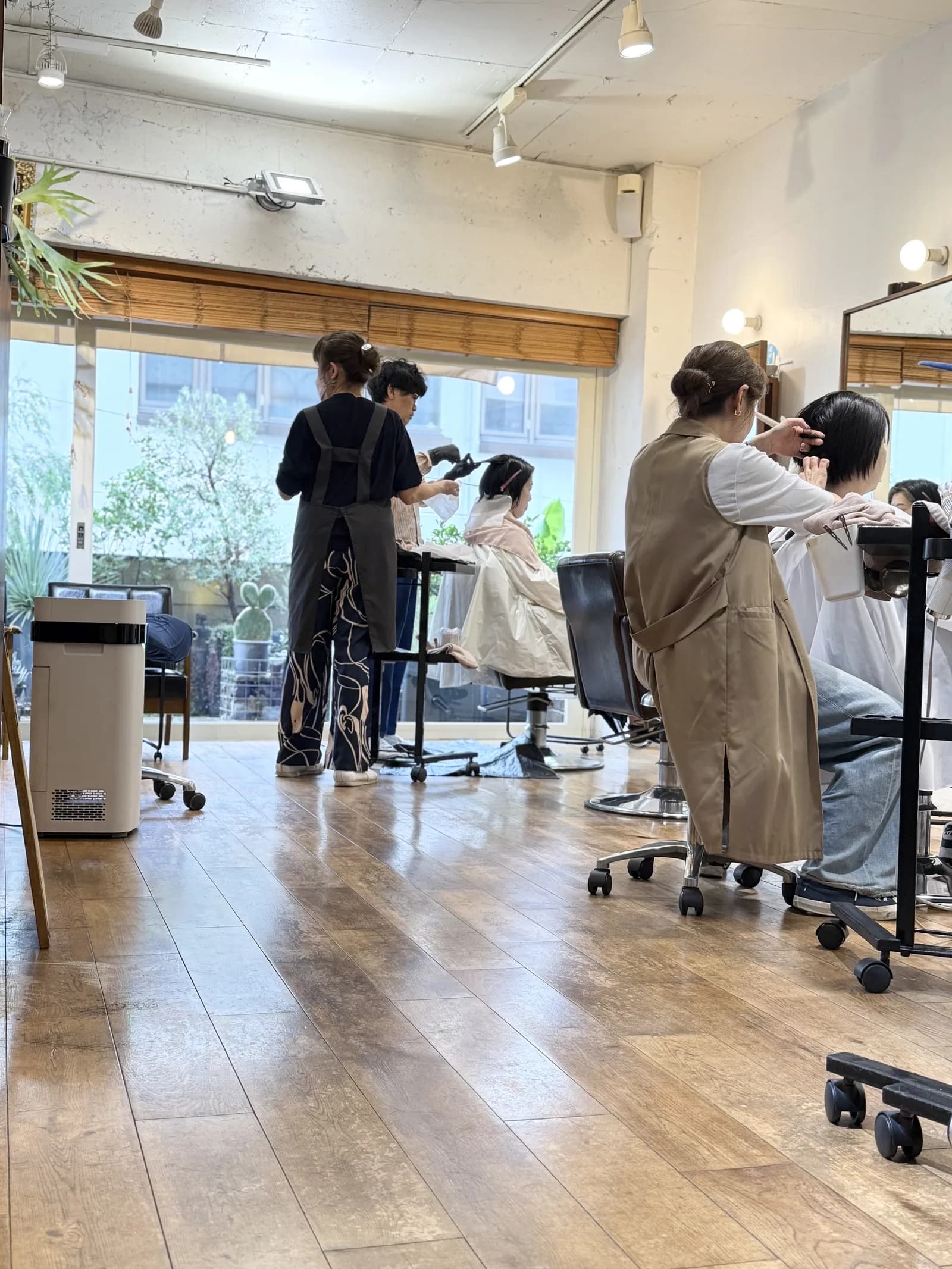 自然光のさし込む店内で施術にあたるスタッフとお客様